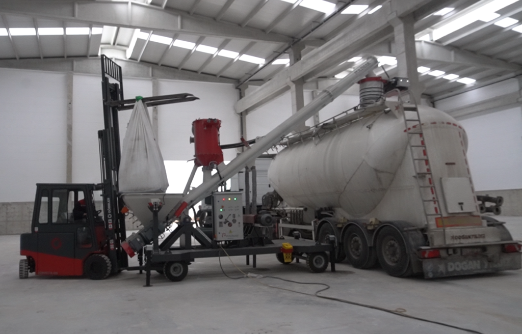 Cement bulk truck loading Cement railer truck is being loaded from bulk bags using forklift